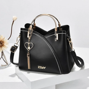 Chic black handbag with contrast white stitching, gold ring handle and heart tassel charm