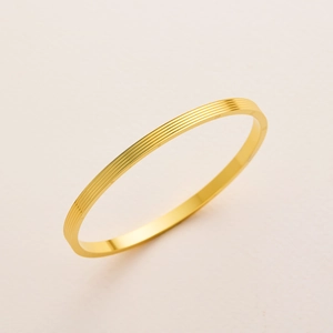 Minimalist gold titanium steel bangle with linear grooves and size numbers for women