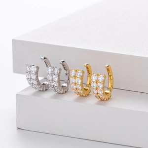 Macro shot of silver and gold trapezoid earrings with paved cubic zirconia on display