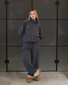 Detail of dark gray polar fleece tracksuit set featuring hoodie with white letter embroidery