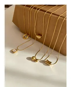 Detailed macro shot of assorted gold titanium steel necklaces on a vintage paper box