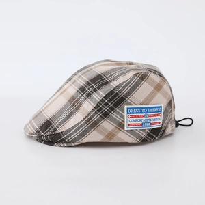 Close-up of vintage plaid beret for kids featuring a side label and adjustable cord