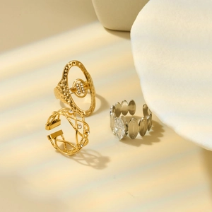Detailed view of geometric gold and silver rings with zircons and brushed texture