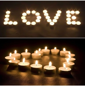 Close-up of white tea light candles in aluminum shells forming a heart shape for decor