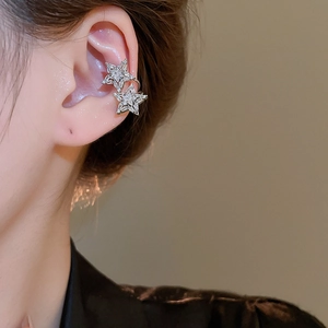 Detail of silver double star ear cuff with sparkling zircon on model ear bone