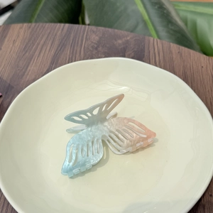 Pince à cheveux papillon bleu dégradé avec motif étoile de mer sur plat en céramique
