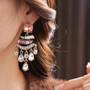 Detailed shot of vintage bronze earrings featuring orange gems and crystal tassels