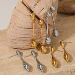 Minimalist long water drop earring set in polished gold and silver finishes on stone