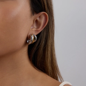 Luxe mixed gold and silver C-shaped stainless steel layered hoop earrings on model