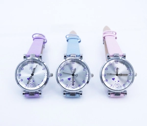 Vue détaillée de trois montres à quartz en lilas, bleu ciel et rose avec bracelet perlé