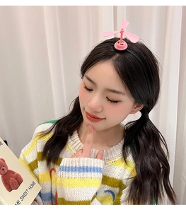 Pink propeller headband accessory worn by a girl for a playful and cute creative look