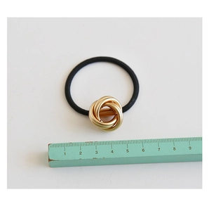 Close-up showing a 3.5cm wide gold metal hair ring with black elastic band