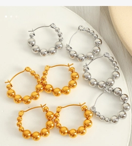 Macro shot of geometric beaded hoop earrings in polished gold and silver finishes