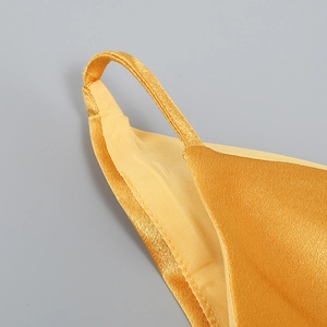 Détails de la robe en satin doré montrant les coutures de la bretelle et la finition