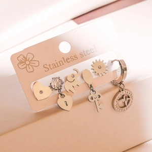 Detailed view of stainless steel earring set featuring heart and sun charm patterns