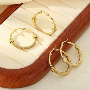 Boucles d'oreilles créoles torsadées dorées en acier inoxydable sur support bijoux