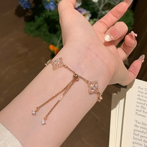 Rose gold clover bracelet with zircons and adjustable slider clasp worn on wrist