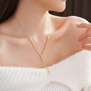 Detail of elegant gold Y-shaped necklace featuring clear geometric zircon tassel charms