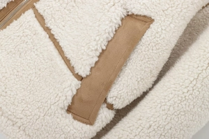 Détail de patchwork en polaire blanche et daim camel avec fermeture éclair et textures
