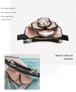 Detailed view of handmade camellia acetate hair clip with pearl center and black alloy base