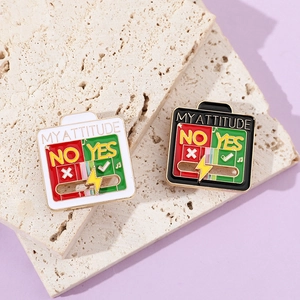 Detail of creative enamel attitude pins with sliding battery level on stone surface