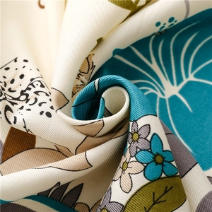 Detailed view of the twill woven texture and tropical floral print on a summer silk shawl