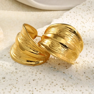 Macro detail of gold plated stainless steel C-shape earrings with irregular hammered texture