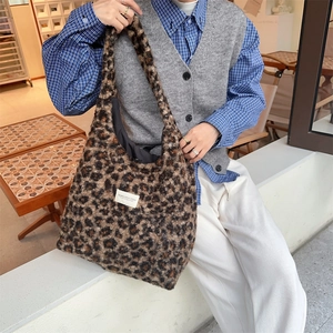 Close-up of leopard print faux shearling tote bag with brand label in a lifestyle setting