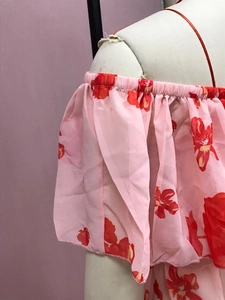 Nahaufnahme des rosa Oberteils mit Blumendruck, elastischen Rüschen und Chiffon-Struktur