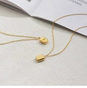 Detailed view of two 18K gold plated square pendants with star engraving and zircon