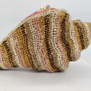 Detail of conch shell luxury clutch with colorful rhinestones and gold metal clasp
