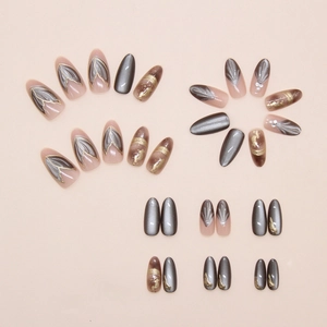 Detailed view of almond-shaped press-on nails with cat-eye effect and pearl gold accents