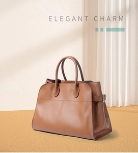 Close-up of a vintage brown leather tote bag with double handles and side buckles