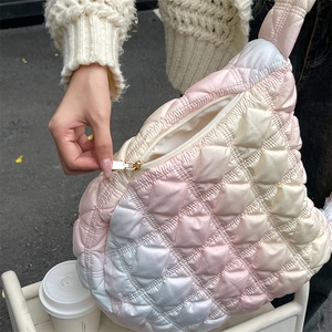 Detailed close-up of the smooth golden zipper and quilted texture on the gradient cloud bag