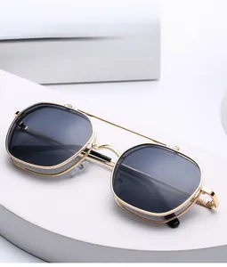 Detail of gold metal double bridge frames and dark lenses on modern fashion sunglasses