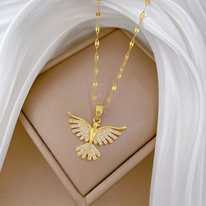 Macro view of gold-tone phoenix bird pendant necklace with sparkling pavé crystal details