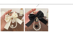 Detail of elegant satin bow keychains with pearl ring and embossed metal fashion tags