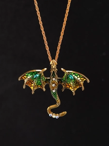 Macro detail of golden dragon pendant with colorful rhinestones and green enamel wings