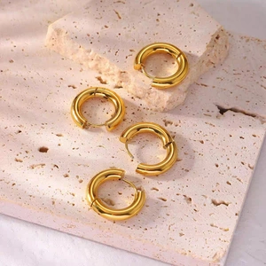Polished thick gold hoop earrings set for women presented on a minimalist stone background