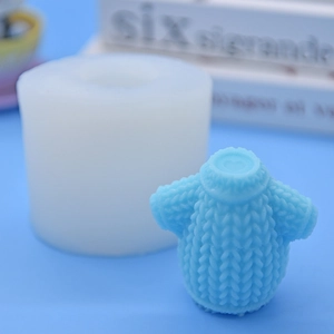 Detailed view of white silicone mold and blue sweater texture candle on light blue background