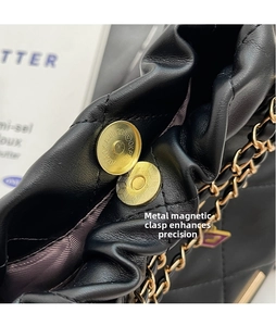 Detail of gold magnetic buckle and black quilted leather on luxury chain bucket bag