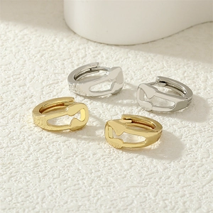 Detailed macro view of 18K gold plated heart-shaped safety pin earrings with cubic zirconia