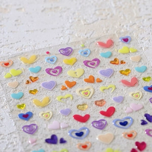 3D embossed heart nail stickers in assorted macaron colors on white stone texture