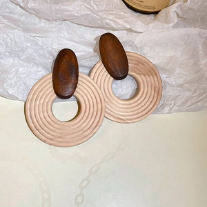 Detail view of the geometric wooden earring with dark brown and beige textures