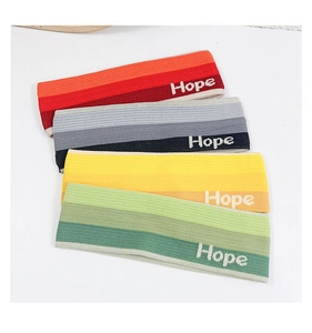 Detail view of knitted sports headbands with Hope embroidery and gradient colors