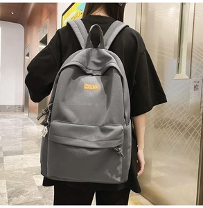 Detail of grey backpack featuring COOLBOY embroidery and durable canvas texture on the front
