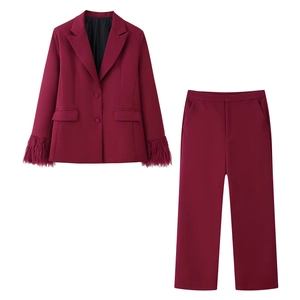 Completo bordeaux da donna con blazer caratterizzato da polsini in piuma e pantaloni coordinati