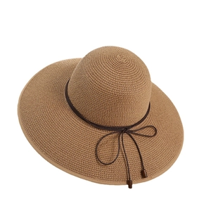 Sommerlicher Strohhut mit breiter Krempe und brauner Kordel für den Strandurlaub