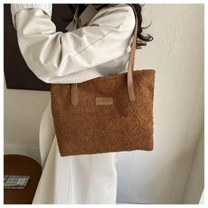 Detail of the soft brown faux fur texture and leather straps on the large tote bag