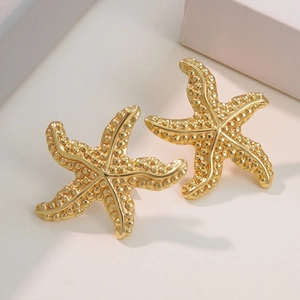 Minimalist gold starfish earrings with textured surface and metallic luster on white background